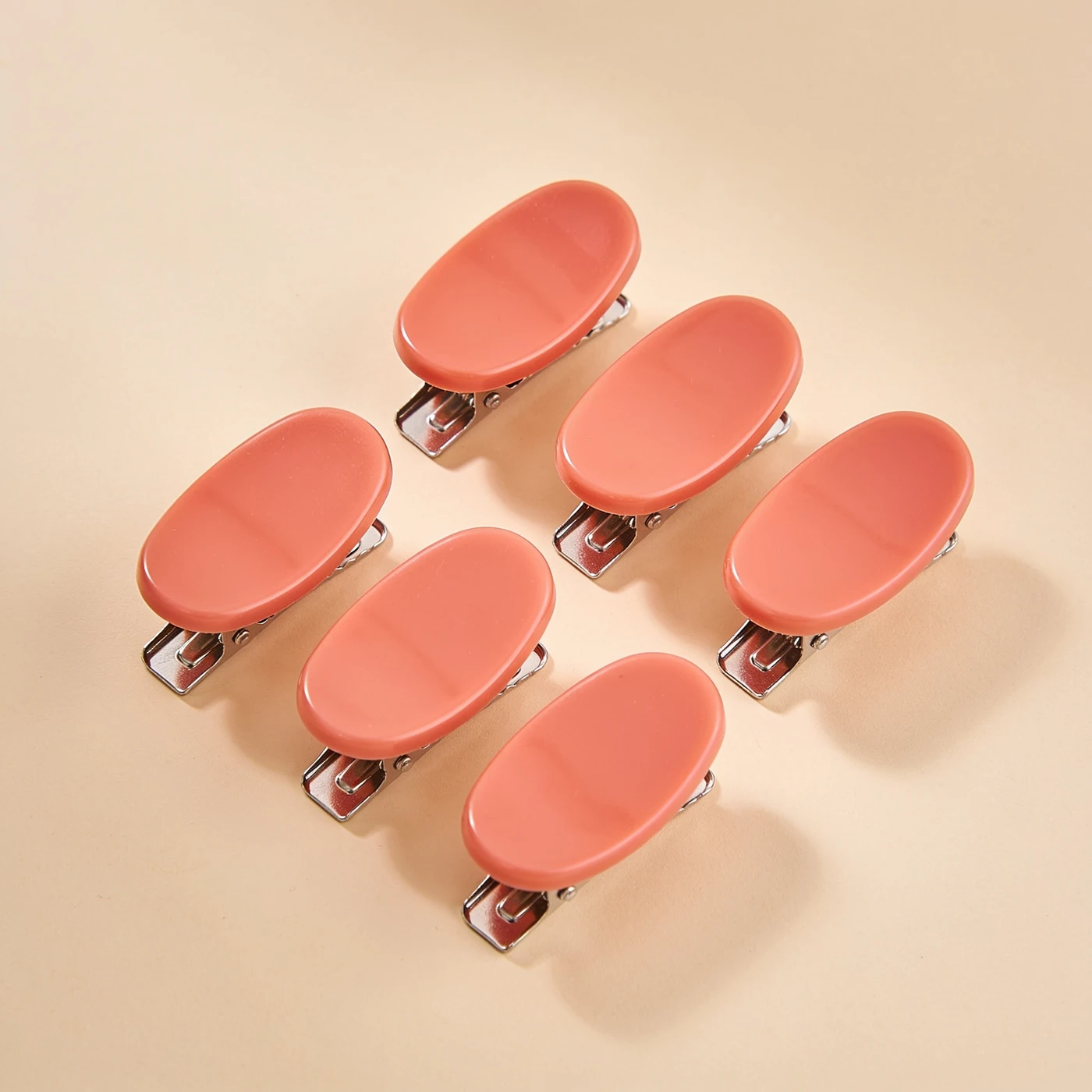 Crease-free Flat Clips — six coral flat resin pads over metal duckbill springs